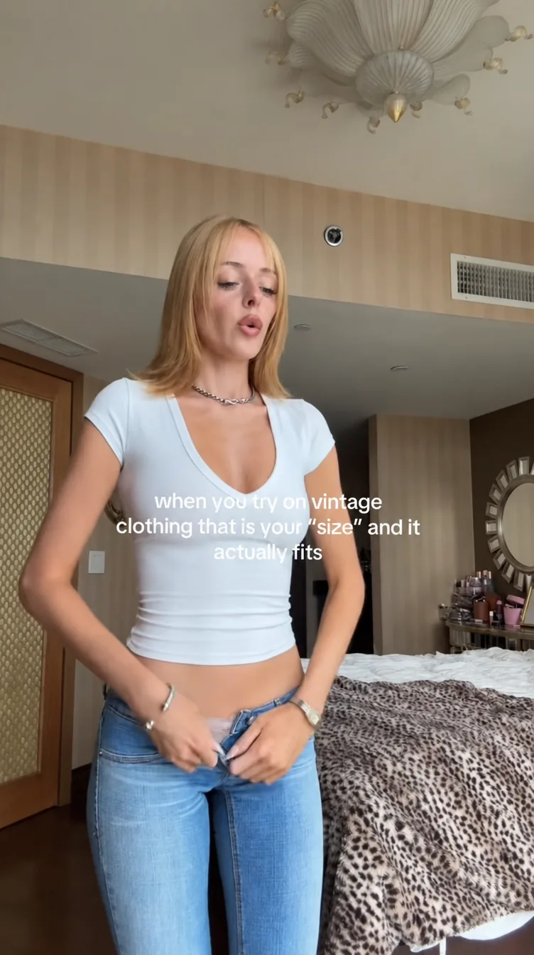 A creator trying on vintage clothing in a short-form video.